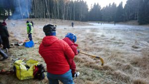 Vi snörar på skridskorna på en stock i kanten.